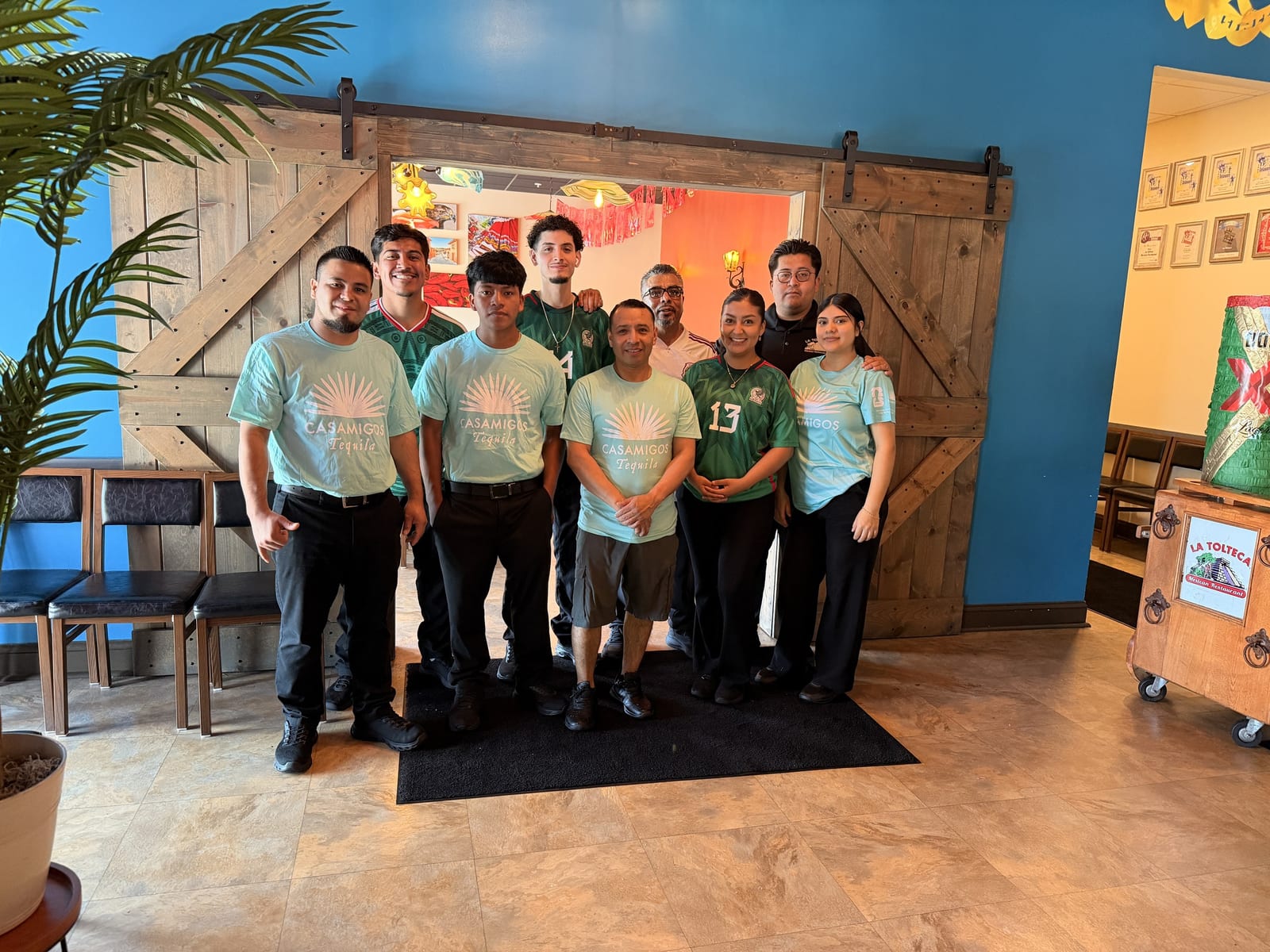 The La Tolteca team in front of the restaurant's barn-door wall